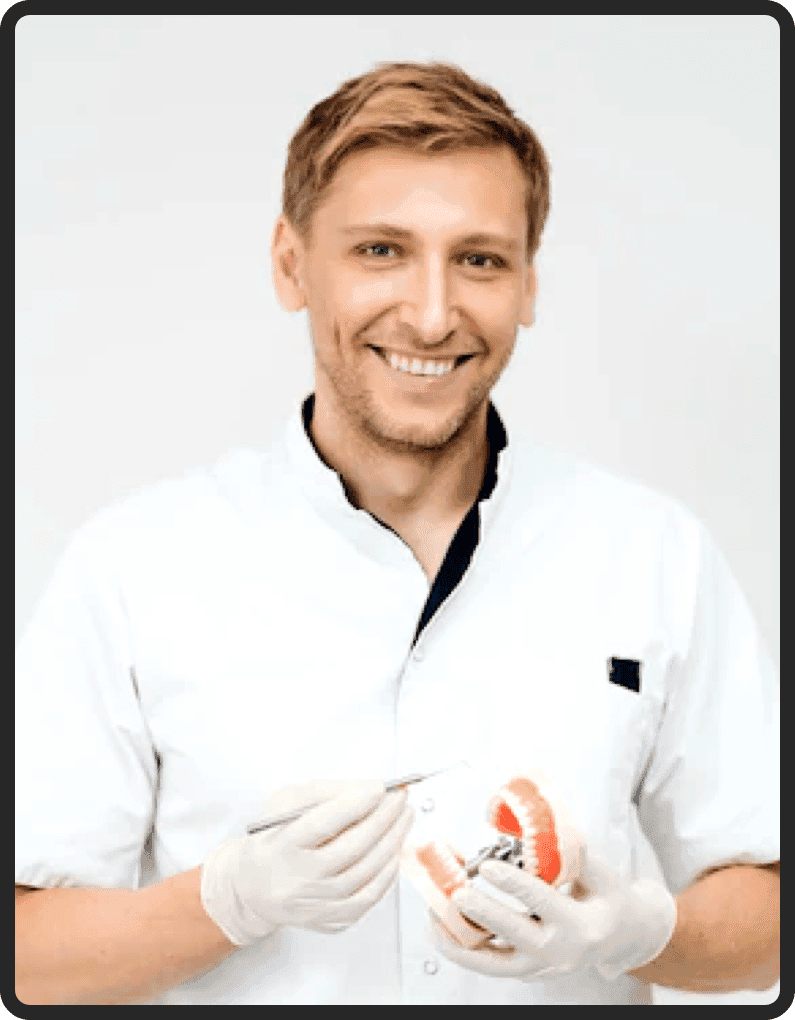 A dental professional in a white coat